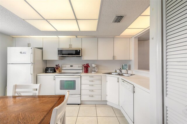 961 S Lakewood Ter Unit C, Port Orange, FL 32127 - kitchen with white appliances, light countertops, light tile patterned floors, and a paneled ceiling