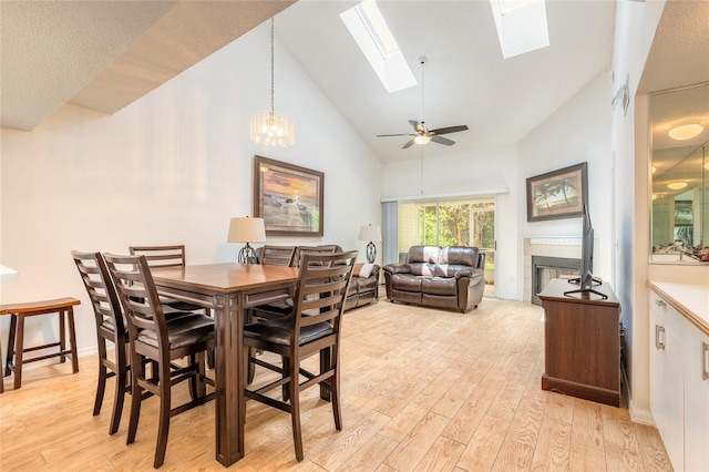 961 S Lakewood Ter Unit C, Port Orange, FL 32127 - dining space with a fireplace, high vaulted ceiling, a skylight, light wood-style floors, and a ceiling fan