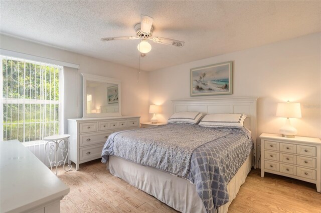 961 S Lakewood Ter Unit C, Port Orange, FL 32127 - bedroom featuring light wood-style flooring, a textured ceiling, and ceiling fan