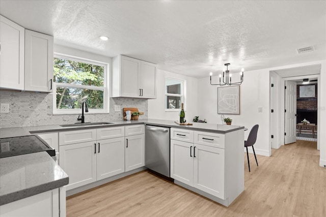 3655 Scott St, Port Orange, FL 32129 - kitchen with stainless steel dishwasher, a peninsula, decorative backsplash, white cabinetry, and light wood-style flooring