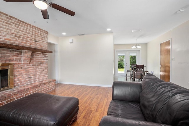 502 W Hogle Ave, Deland, FL 32720 - living room with wood finished floors, ceiling fan, a fireplace, a chandelier, and recessed lighting