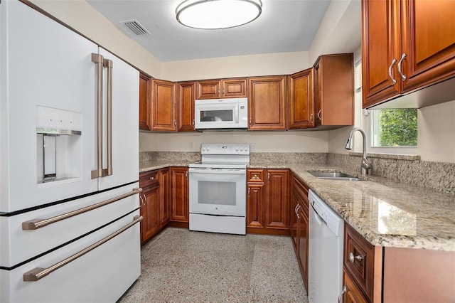 502 W Hogle Ave, Deland, FL 32720 - kitchen with white appliances, brown cabinets, light stone counters, and dark aggregate flooring