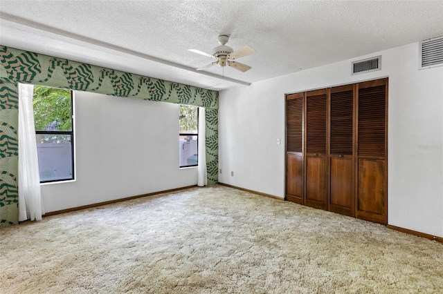8 Rising Moon Trl, Ormond Beach, FL 32174 - unfurnished bedroom featuring a textured ceiling, carpet, a closet, and a ceiling fan