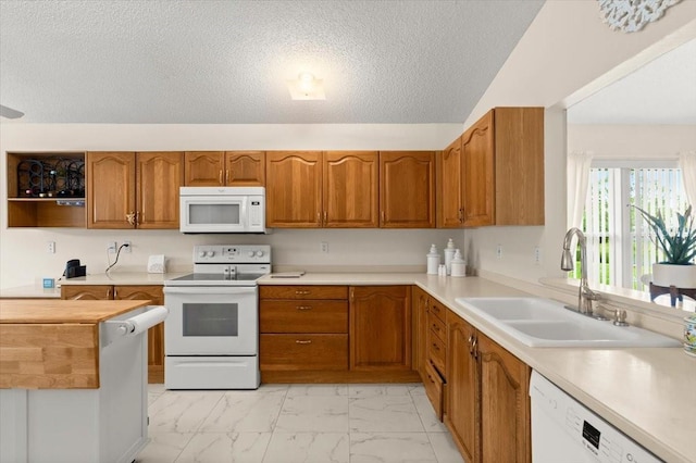 123 Wood Ibis Ct, Daytona Beach, FL 32119 - kitchen with white appliances, light marble finish floors, brown cabinets, a textured ceiling, and light countertops