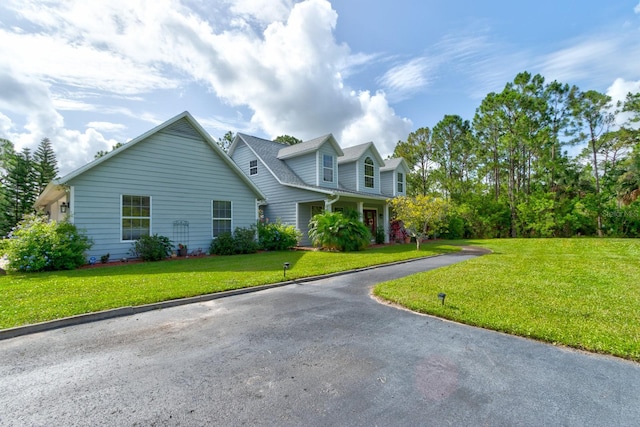 1383 Tumblin Dr, New Smyrna Beach, FL 32168 - view of front facade featuring a front yard and asphalt driveway