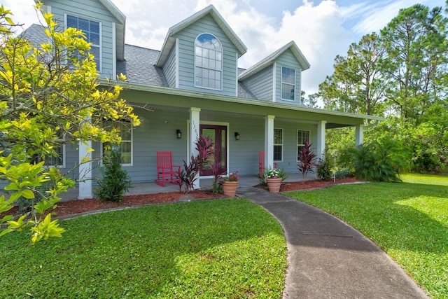 1383 Tumblin Dr, New Smyrna Beach, FL 32168 - view of front of house with covered porch, a front yard, and roof with shingles