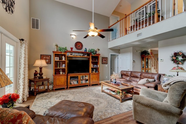 1383 Tumblin Dr, New Smyrna Beach, FL 32168 - living area featuring high vaulted ceiling, wood finished floors, stairway, and ceiling fan