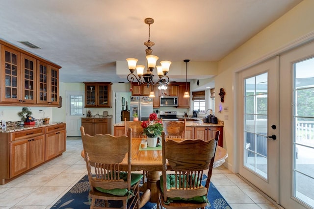 1383 Tumblin Dr, New Smyrna Beach, FL 32168 - dining room featuring light tile patterned floors, a chandelier, and french doors