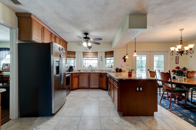 1383 Tumblin Dr, New Smyrna Beach, FL 32168 - kitchen with appliances with stainless steel finishes, a peninsula, a ceiling fan, dark stone countertops, and brown cabinets