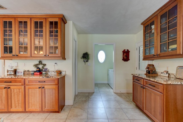 1383 Tumblin Dr, New Smyrna Beach, FL 32168 - kitchen featuring light stone countertops, glass insert cabinets, and brown cabinets