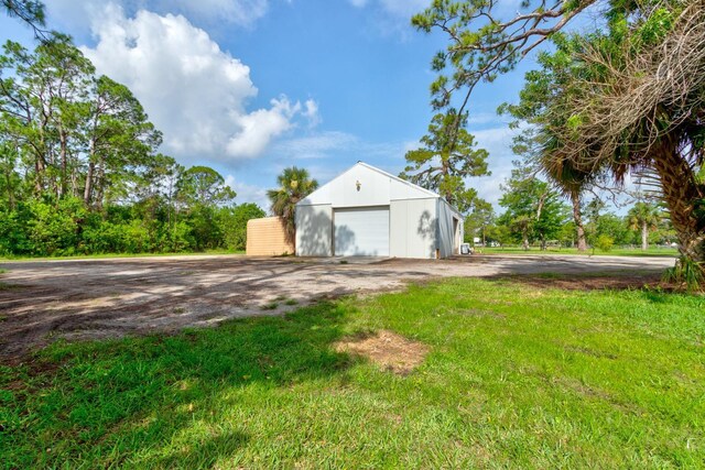 1383 Tumblin Dr, New Smyrna Beach, FL 32168 - view of yard featuring a detached garage, an outdoor structure, and an outbuilding