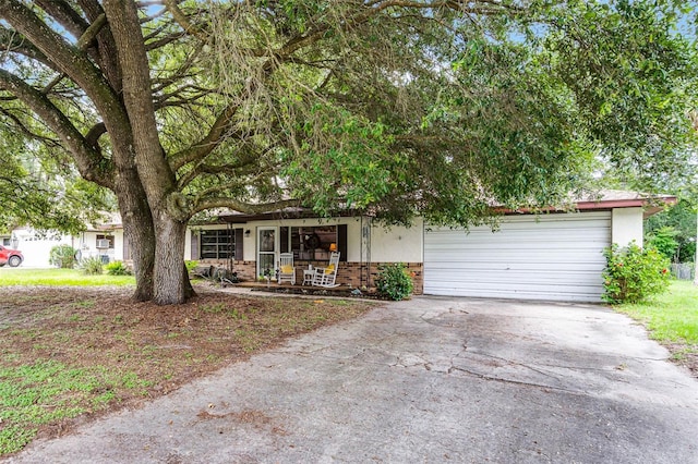 270 Sandyhook Ln, Deland, FL 32724 - obstructed view of property with brick siding, concrete driveway, covered porch, and an attached garage