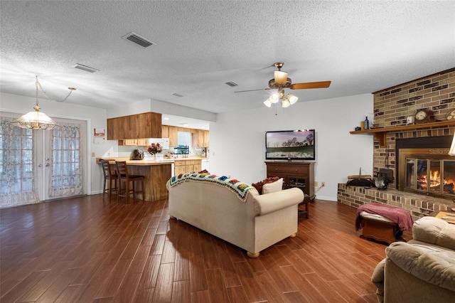 270 Sandyhook Ln, Deland, FL 32724 - living area featuring dark wood-style floors, a ceiling fan, a textured ceiling, and a fireplace