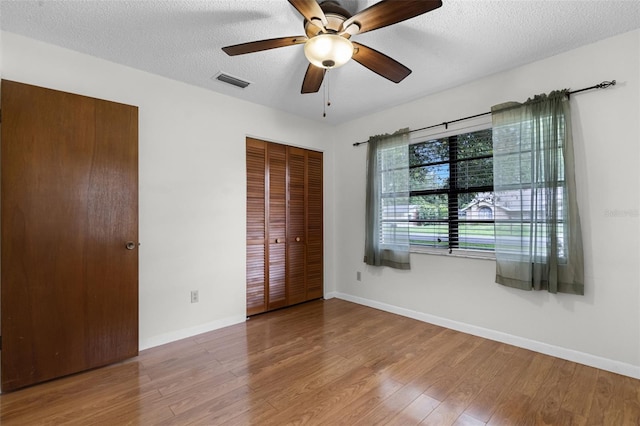 270 Sandyhook Ln, Deland, FL 32724 - unfurnished bedroom featuring wood finished floors, a textured ceiling, a ceiling fan, and a closet