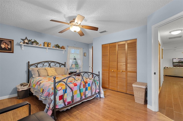 270 Sandyhook Ln, Deland, FL 32724 - bedroom with light wood-style floors, a closet, a textured ceiling, and a ceiling fan