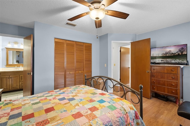 270 Sandyhook Ln, Deland, FL 32724 - bedroom with light wood-style flooring, a closet, a textured ceiling, a ceiling fan, and ensuite bathroom