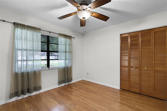 270 Sandyhook Ln, Deland, FL 32724 - unfurnished bedroom featuring wood finished floors, a textured ceiling, a closet, and a ceiling fan