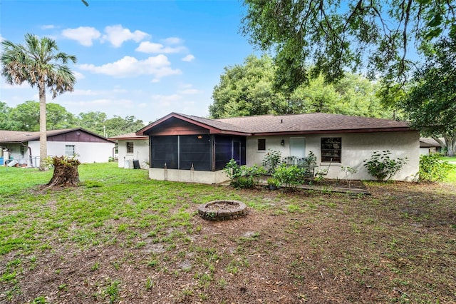 270 Sandyhook Ln, Deland, FL 32724 - rear view of property featuring a sunroom, stucco siding, a fire pit, and a yard