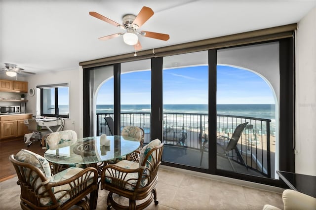 3003 S Atlantic Ave Unit 3A2, Daytona Beach Shores, FL 32118 - dining space featuring ceiling fan, view of water and beach, and light tile patterned floors