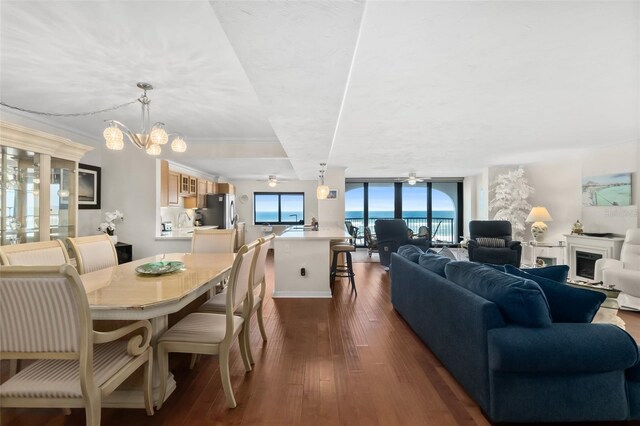 3003 S Atlantic Ave Unit 3A2, Daytona Beach Shores, FL 32118 - dining area featuring dark wood-type flooring, a wall of windows, a chandelier, and a fireplace