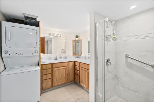 3003 S Atlantic Ave Unit 3A2, Daytona Beach Shores, FL 32118 - bathroom featuring stacked washer / dryer, a stall shower, and vanity