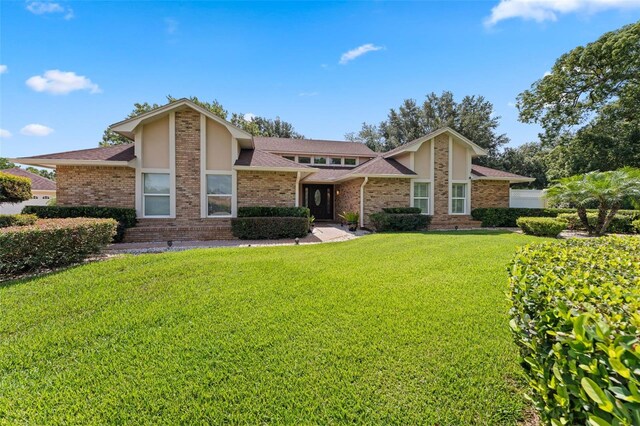 3 Pine Meadow Ct, Debary, FL 32713 - mid-century modern home with a front lawn, stucco siding, brick siding, and roof with shingles