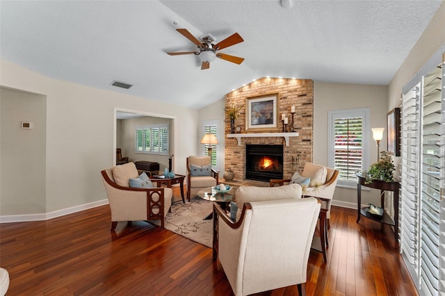 3 Pine Meadow Ct, Debary, FL 32713 - living area featuring a brick fireplace, a ceiling fan, vaulted ceiling, dark wood-style floors, and a textured ceiling