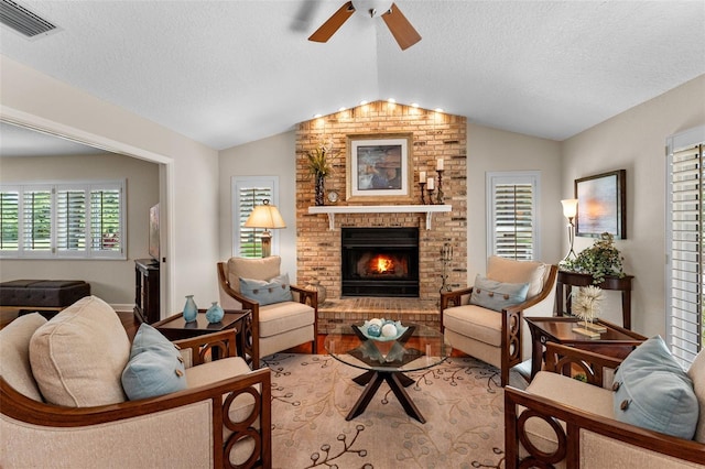 3 Pine Meadow Ct, Debary, FL 32713 - living room with vaulted ceiling, ceiling fan, a fireplace, light wood-style floors, and a textured ceiling