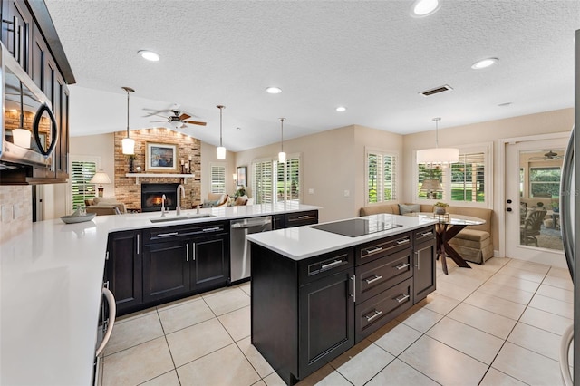 3 Pine Meadow Ct, Debary, FL 32713 - kitchen with appliances with stainless steel finishes, a ceiling fan, a fireplace, open floor plan, and light countertops