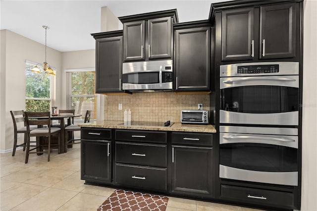 727 Grape Ivy Ln, New Smyrna Beach, FL 32168 - kitchen featuring stainless steel appliances, dark cabinetry, tasteful backsplash, and a chandelier