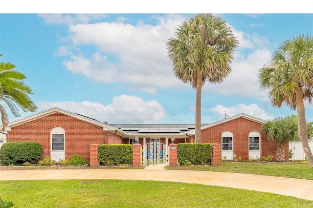 2724 N Halifax Ave, Daytona Beach, FL 32118 - view of front of property with brick siding, a gate, and solar panels