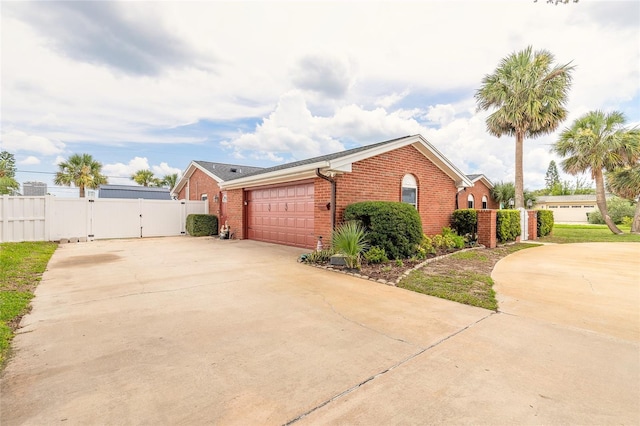 2724 N Halifax Ave, Daytona Beach, FL 32118 - view of side of home featuring a gate, driveway, brick siding, and a garage