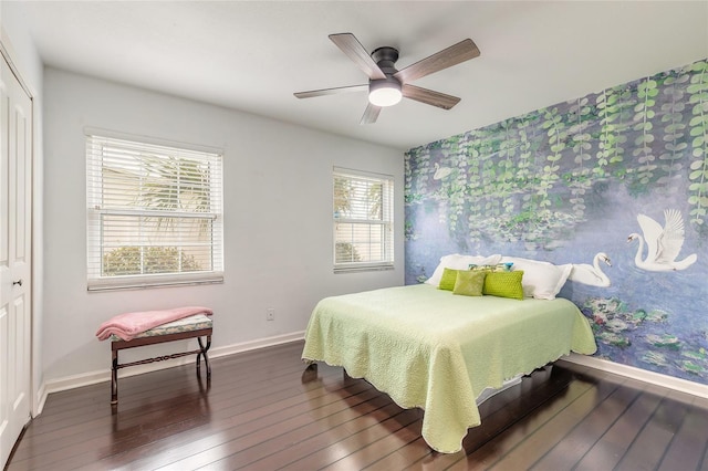 2724 N Halifax Ave, Daytona Beach, FL 32118 - bedroom featuring dark wood finished floors, an accent wall, a closet, wallpapered walls, and a ceiling fan