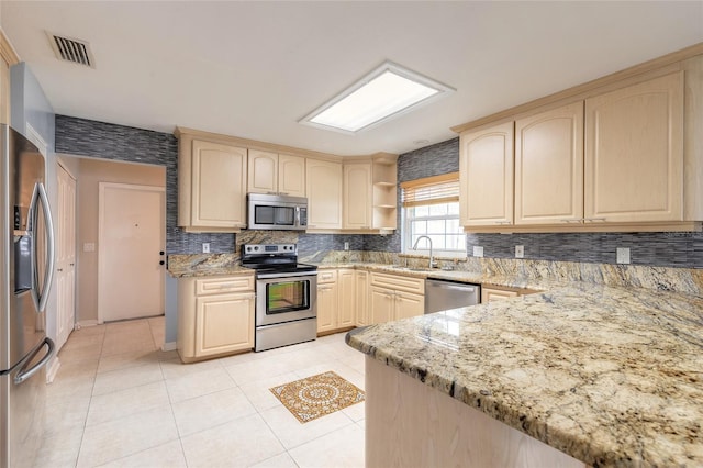 2724 N Halifax Ave, Daytona Beach, FL 32118 - kitchen with appliances with stainless steel finishes, backsplash, light brown cabinets, and light stone counters