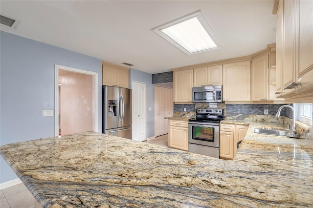 2724 N Halifax Ave, Daytona Beach, FL 32118 - kitchen with appliances with stainless steel finishes, light brown cabinetry, backsplash, light stone counters, and a peninsula