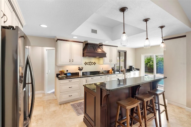 1261 Burning Tree Ln, Winter Park, FL 32792 - kitchen with freestanding refrigerator, custom exhaust hood, dark countertops, black electric cooktop, and a textured ceiling