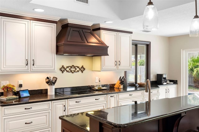 1261 Burning Tree Ln, Winter Park, FL 32792 - kitchen featuring custom range hood, black electric cooktop, healthy amount of natural light, white cabinetry, and recessed lighting