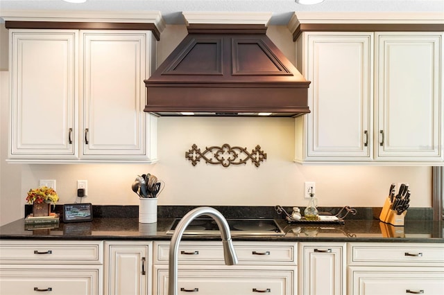 1261 Burning Tree Ln, Winter Park, FL 32792 - kitchen with premium range hood, black electric cooktop, white cabinetry, and dark stone counters