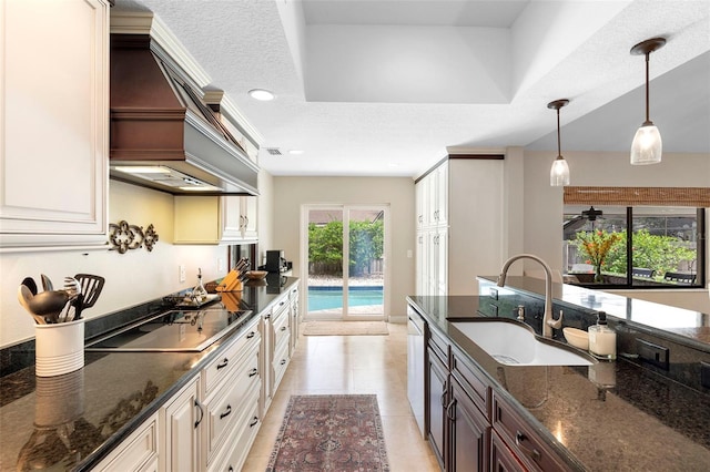 1261 Burning Tree Ln, Winter Park, FL 32792 - kitchen with black electric stovetop, premium range hood, hanging light fixtures, dark stone counters, and recessed lighting