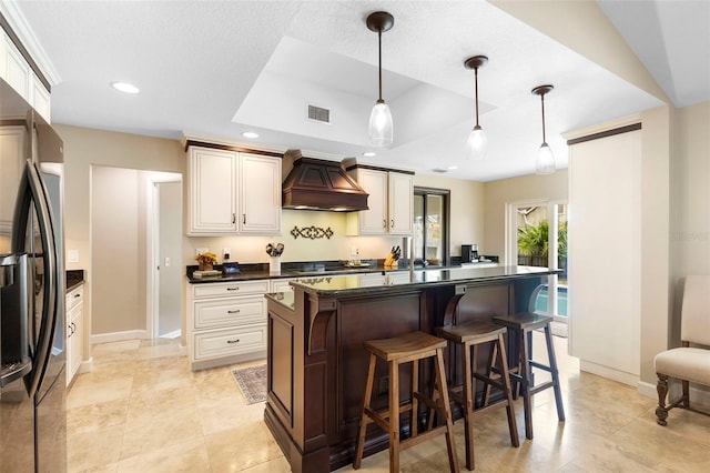 1261 Burning Tree Ln, Winter Park, FL 32792 - kitchen featuring premium range hood, dark countertops, freestanding refrigerator, a tray ceiling, and recessed lighting