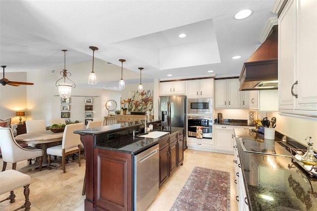 1261 Burning Tree Ln, Winter Park, FL 32792 - kitchen featuring stainless steel appliances, custom range hood, a ceiling fan, a center island with sink, and white cabinets