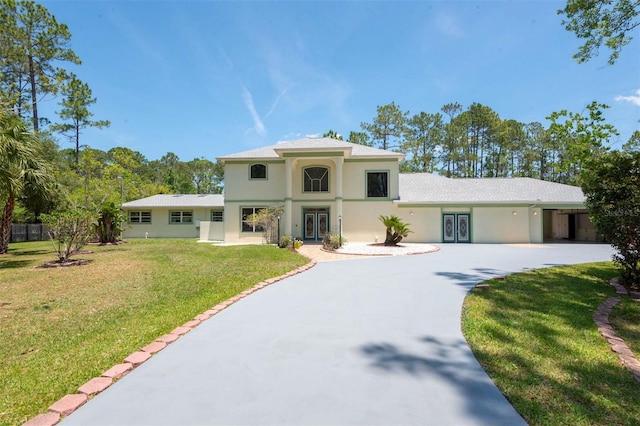 3428 Longleaf Rd, Ormond Beach, FL 32174 - mediterranean / spanish-style house with french doors, stucco siding, a front yard, and curved driveway