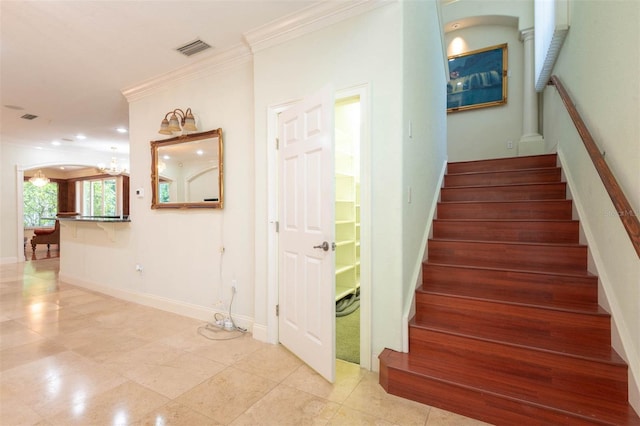 3428 Longleaf Rd, Ormond Beach, FL 32174 - stairway with ornamental molding, a chandelier, arched walkways, and tile patterned flooring
