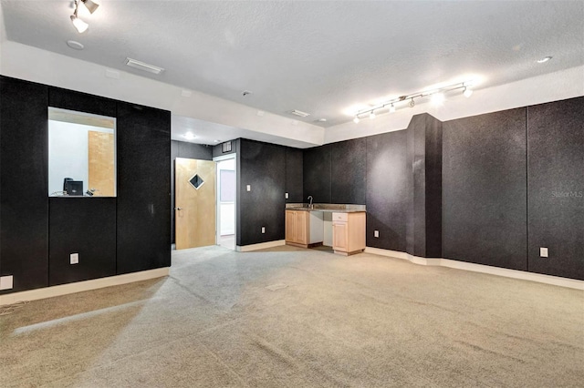 3428 Longleaf Rd, Ormond Beach, FL 32174 - empty room with bar with sink, light colored carpet, a textured ceiling, and rail lighting