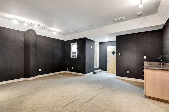 3428 Longleaf Rd, Ormond Beach, FL 32174 - empty room with light colored carpet, a textured ceiling, rail lighting, and a smoke detector