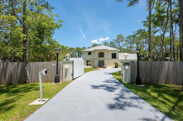 3428 Longleaf Rd, Ormond Beach, FL 32174 - view of front facade featuring a fenced front yard, stucco siding, a gate, and driveway