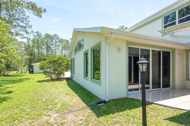 3428 Longleaf Rd, Ormond Beach, FL 32174 - view of side of property featuring stucco siding, a yard, and a patio area