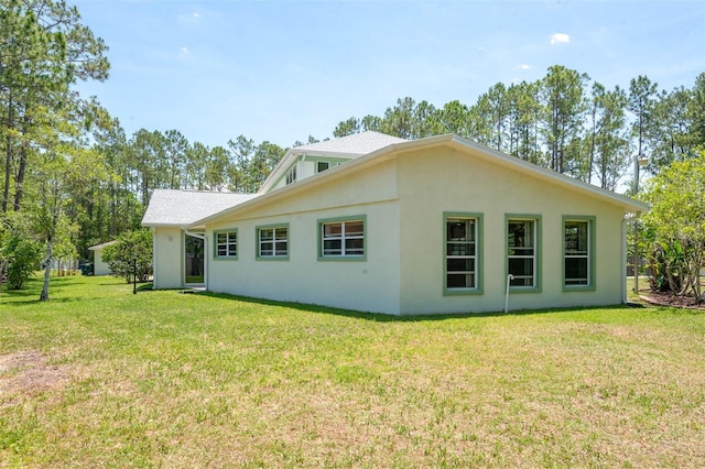 3428 Longleaf Rd, Ormond Beach, FL 32174 - rear view of property with a lawn and stucco siding