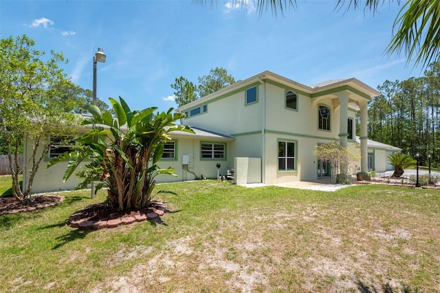 3428 Longleaf Rd, Ormond Beach, FL 32174 - back of property featuring stucco siding, a lawn, and a patio