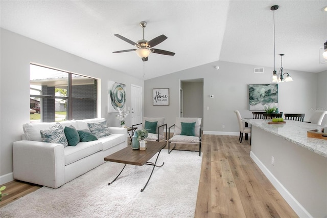 3117 Pine Tree Dr, Edgewater, FL 32141 - living room with light wood-style flooring, lofted ceiling, a ceiling fan, and a chandelier